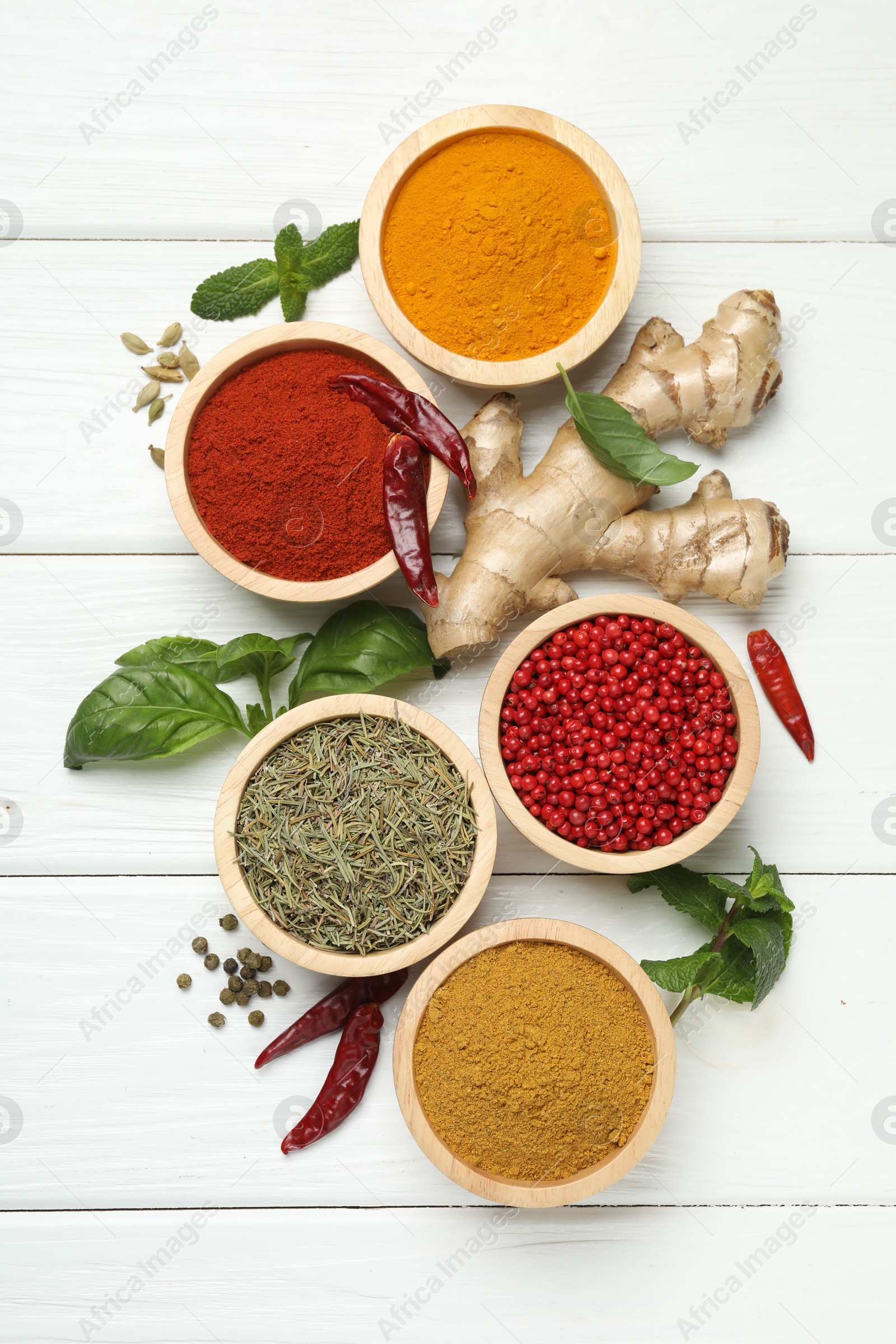 Photo of Different aromatic spices on white wooden table, flat lay