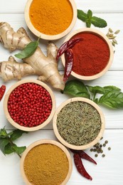 Photo of Different aromatic spices on white wooden table, flat lay