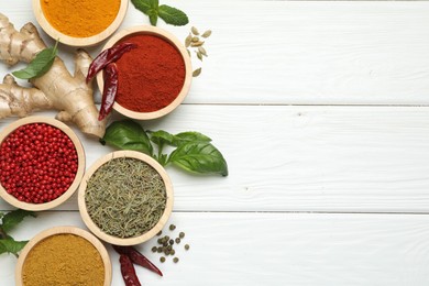 Photo of Different aromatic spices on white wooden table, flat lay. Space for text