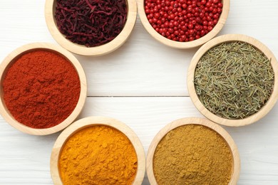 Photo of Different aromatic spices on white wooden table, flat lay