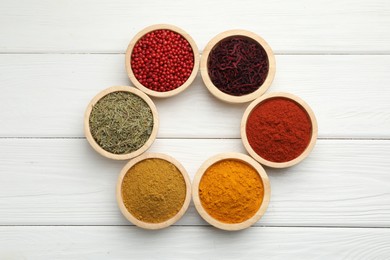 Photo of Different aromatic spices on white wooden table, flat lay