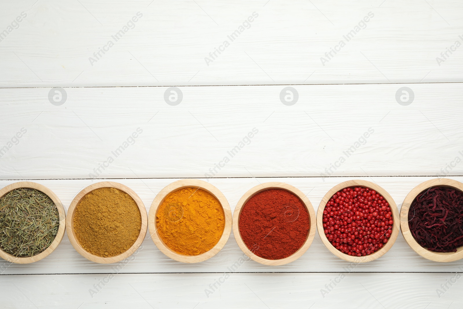 Photo of Different aromatic spices on white wooden table, flat lay. Space for text