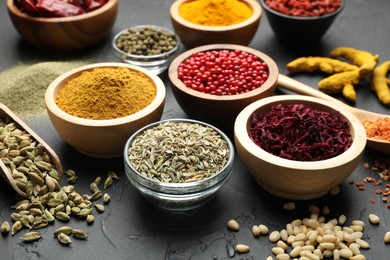 Photo of Different aromatic spices on black table, closeup