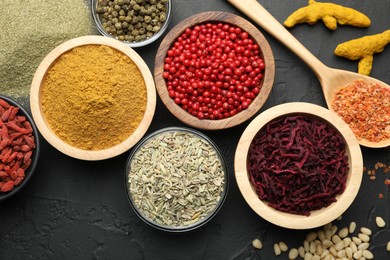 Photo of Different aromatic spices on black table, flat lay