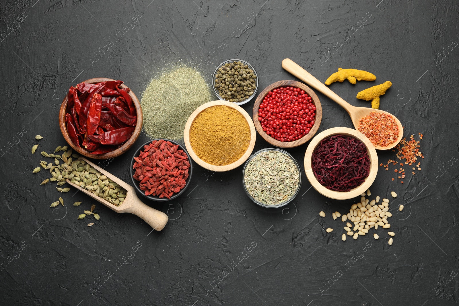 Photo of Different aromatic spices on black table, flat lay