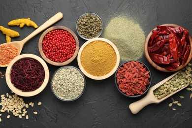 Photo of Different aromatic spices on black table, flat lay