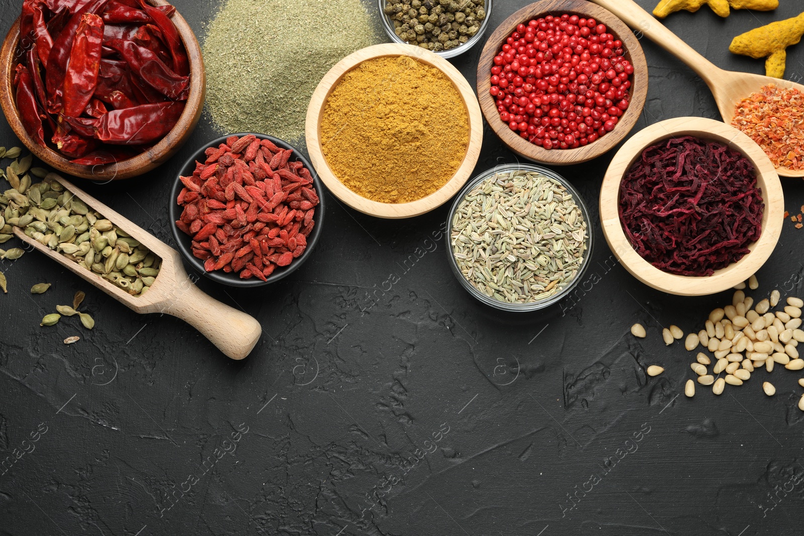 Photo of Different aromatic spices on black table, flat lay. Space for text