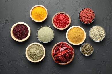 Photo of Different aromatic spices on black table, flat lay