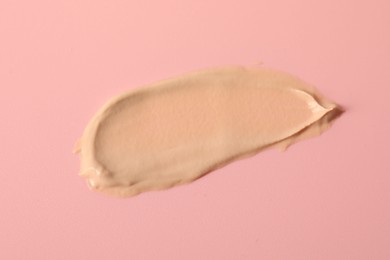 Photo of Sample of foundation on pink background, top view