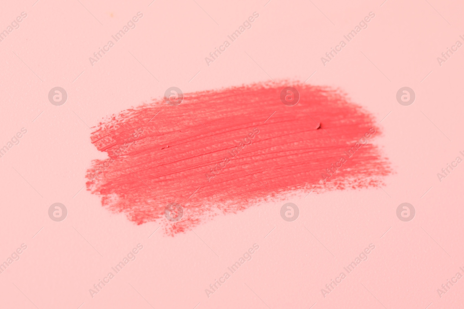 Photo of Sample of pink lipstick on beige background, closeup