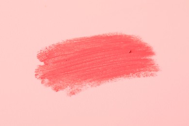 Photo of Sample of pink lipstick on beige background, closeup