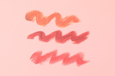 Photo of Samples of bright lipsticks on beige background, top view