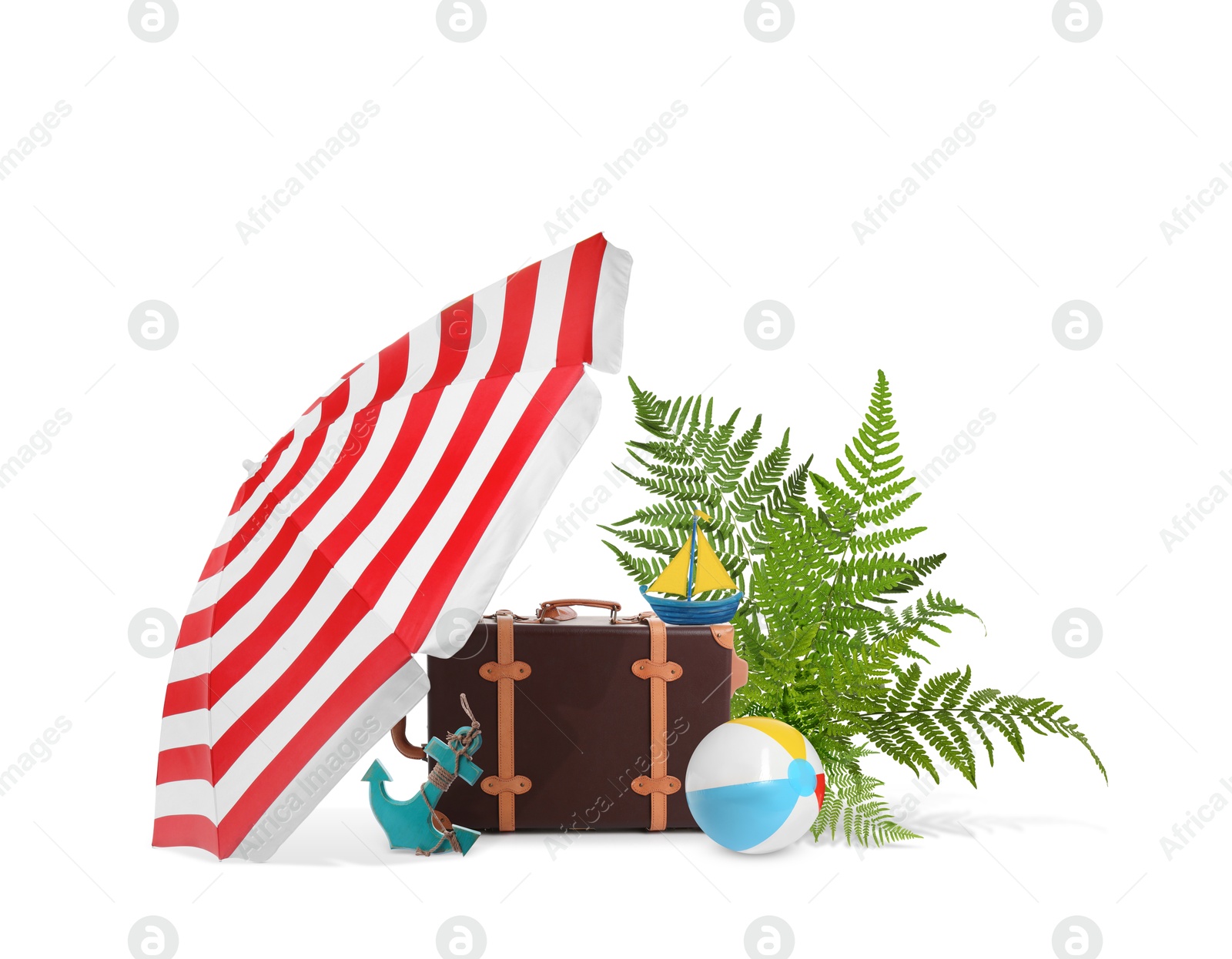 Image of Leather travel suitcase, tropical leaves, toy sailboat and anchor, beach umbrella and ball on white background