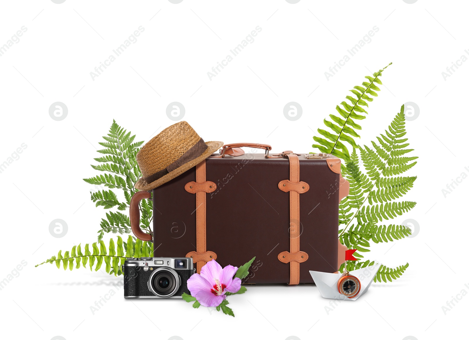 Image of Leather travel suitcase, paper boat with compass, hat, camera, tropical leaves and flower on white background