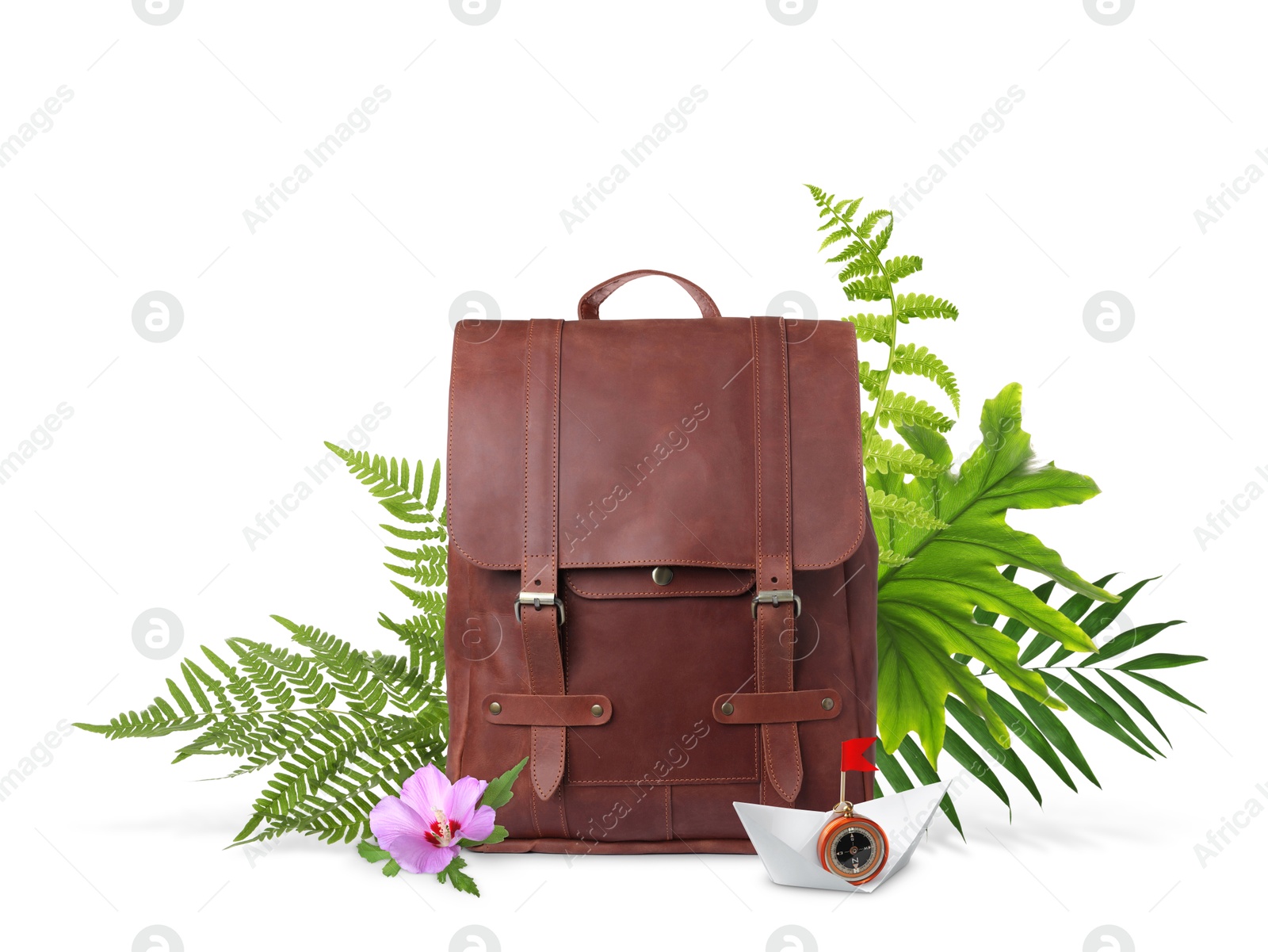 Image of Leather backpack, paper boat with compass, tropical leaves and flower on white background. Time to travel