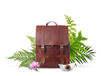 Image of Leather backpack, paper boat with compass, tropical leaves and flower on white background. Time to travel