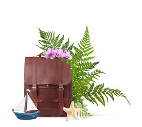 Image of Leather backpack, toy sailboat, sea star, tropical leaves and flowers on white background. Time to travel