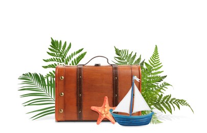 Image of Brown travel suitcase, tropical leaves, sea stars and toy sailboat on white background