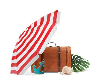 Brown travel suitcase, tropical leaf, seashell, beach umbrella and toy anchor on white background