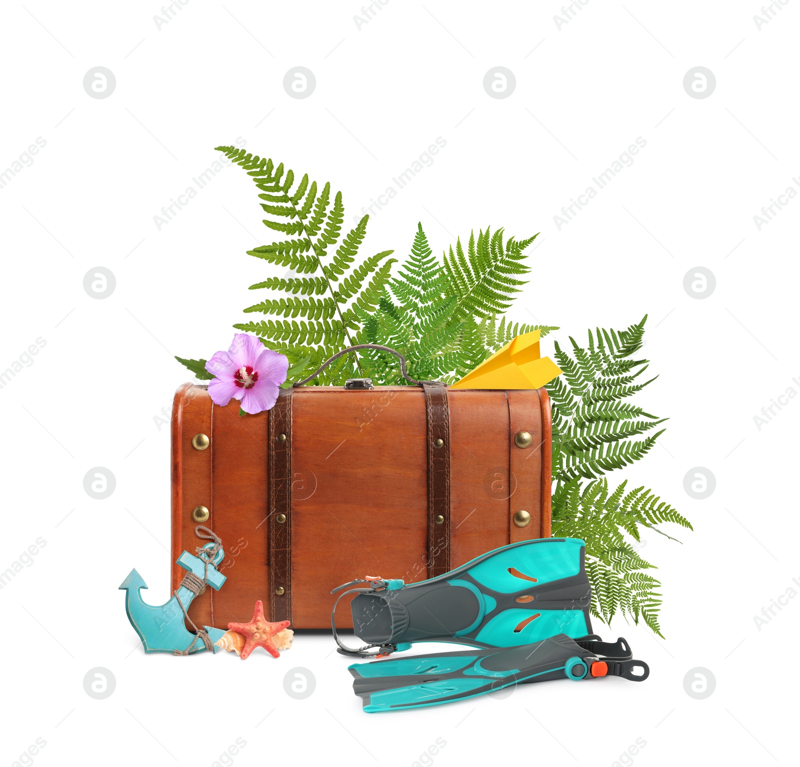 Image of Brown travel suitcase, paper plane, toy anchor, sea star, swim fins, tropical leaves and flower on white background