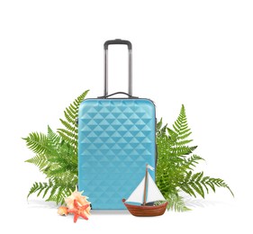 Image of Light blue travel suitcase, tropical leaves, sea star, seashells and toy sailboat on white background