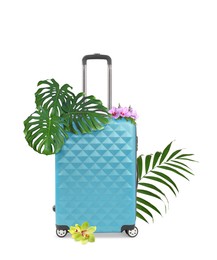 Image of Light blue travel suitcase, tropical leaves and flowers on white background