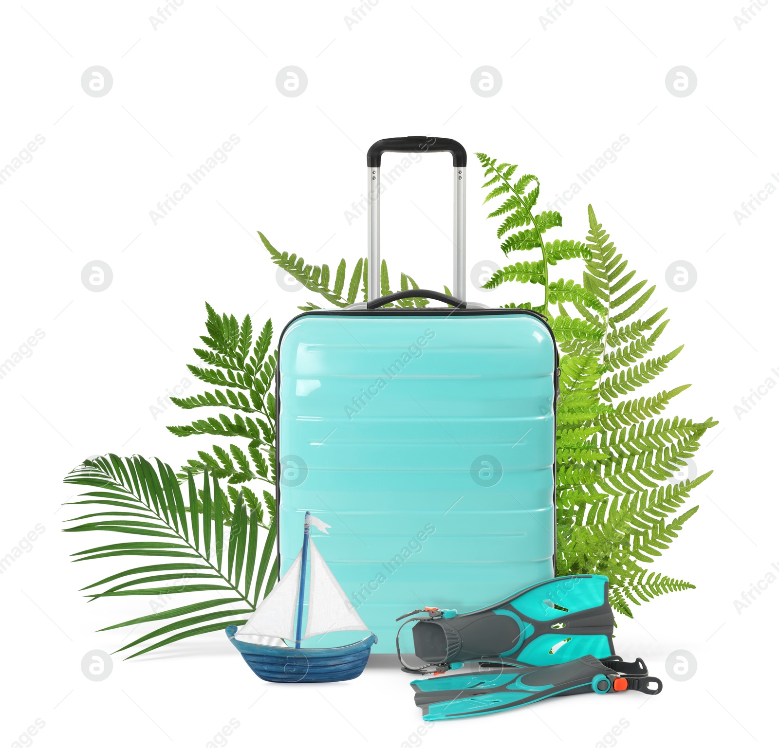 Image of Turquoise travel suitcase, tropical leaves, swim fins and toy sailboat on white background