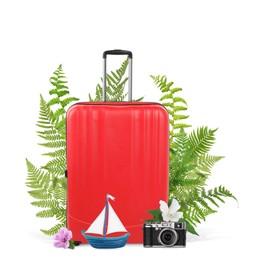 Image of Red travel suitcase, camera, toy sailboat, tropical leaves and flowers on white background