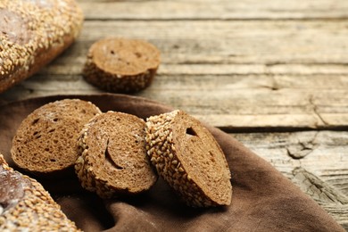 Photo of Fresh baguette with sesame on wooden table, closeup