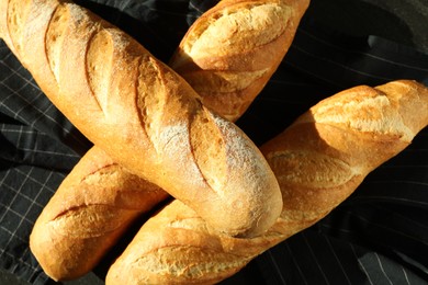 Photo of Freshly baked baguettes on table, top view