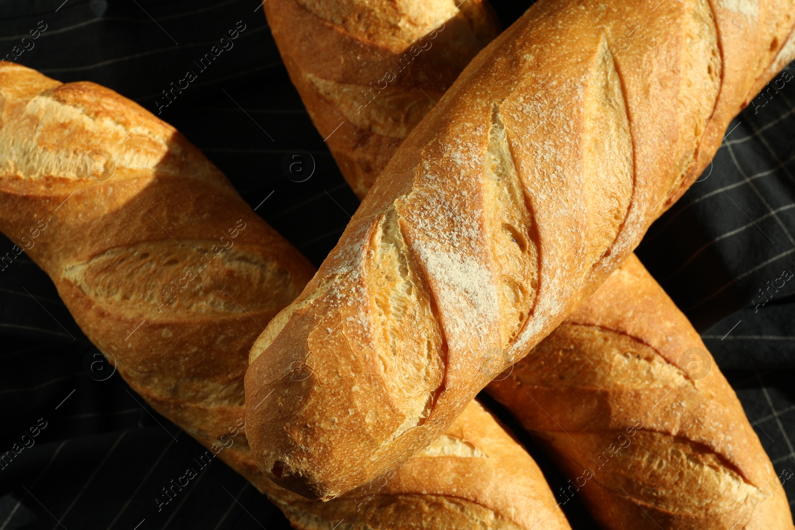 Photo of Freshly baked baguettes on table, top view