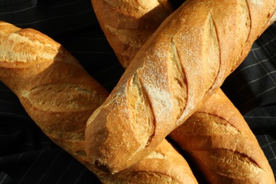 Photo of Freshly baked baguettes on table, top view