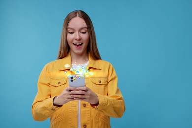 Image of Surprised woman using mobile phone on light blue background. New message sign and other notifications over gadget