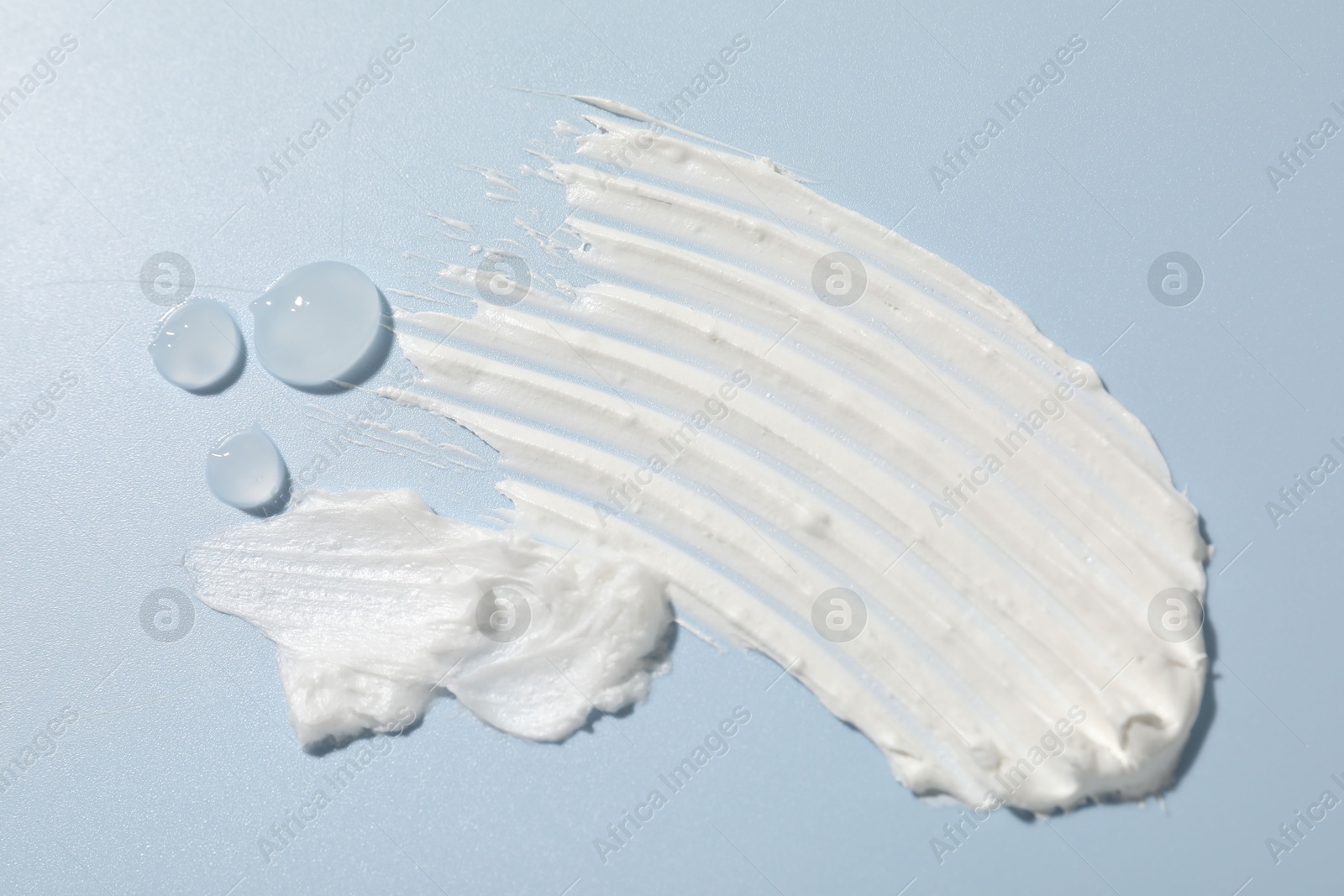 Photo of Different cosmetic products on light blue background, top view