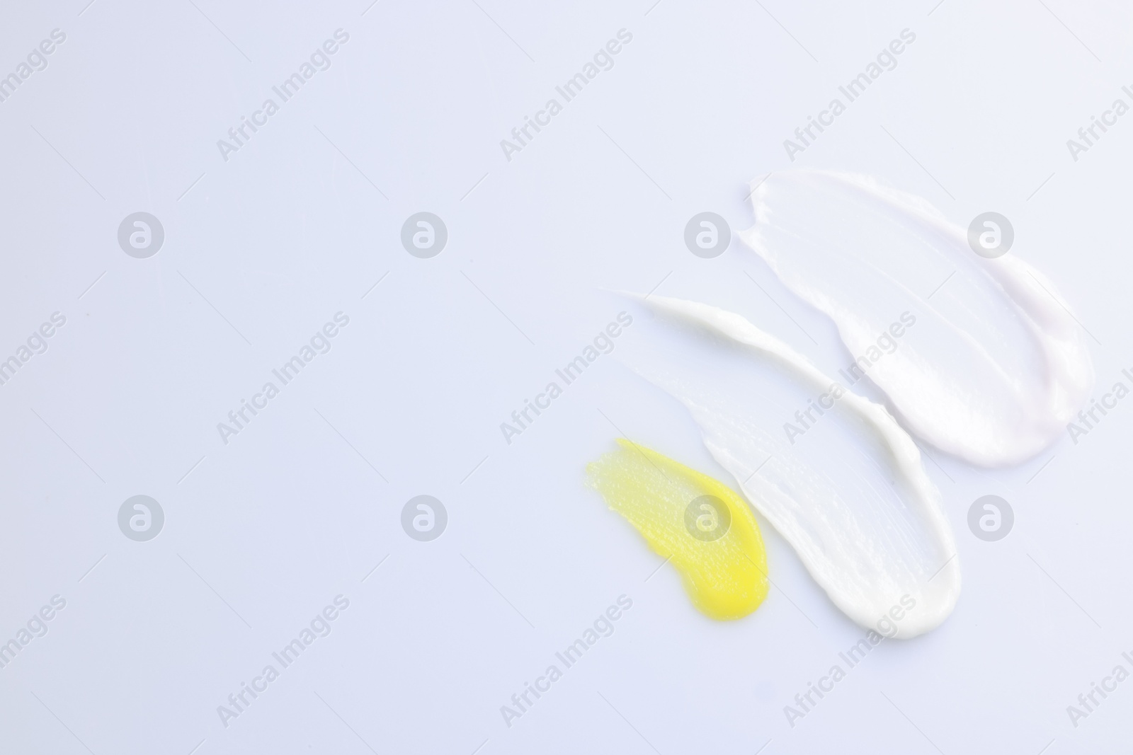 Photo of Samples of cosmetic products on white background, top view. Space for text