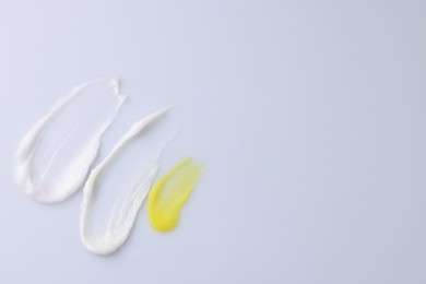 Photo of Samples of cosmetic products on white background, top view. Space for text