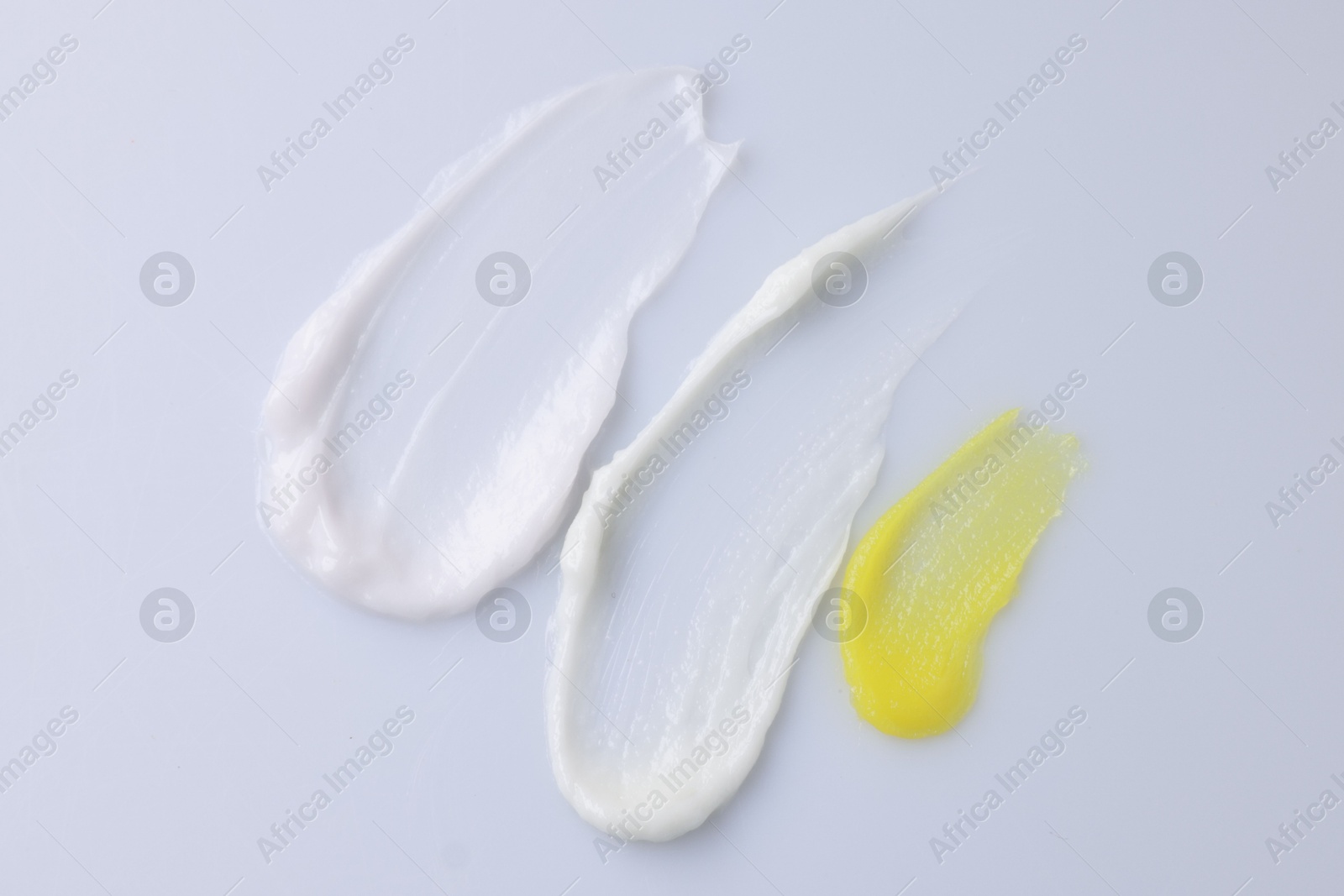 Photo of Samples of cosmetic products on white background, top view