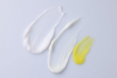 Photo of Samples of cosmetic products on white background, top view