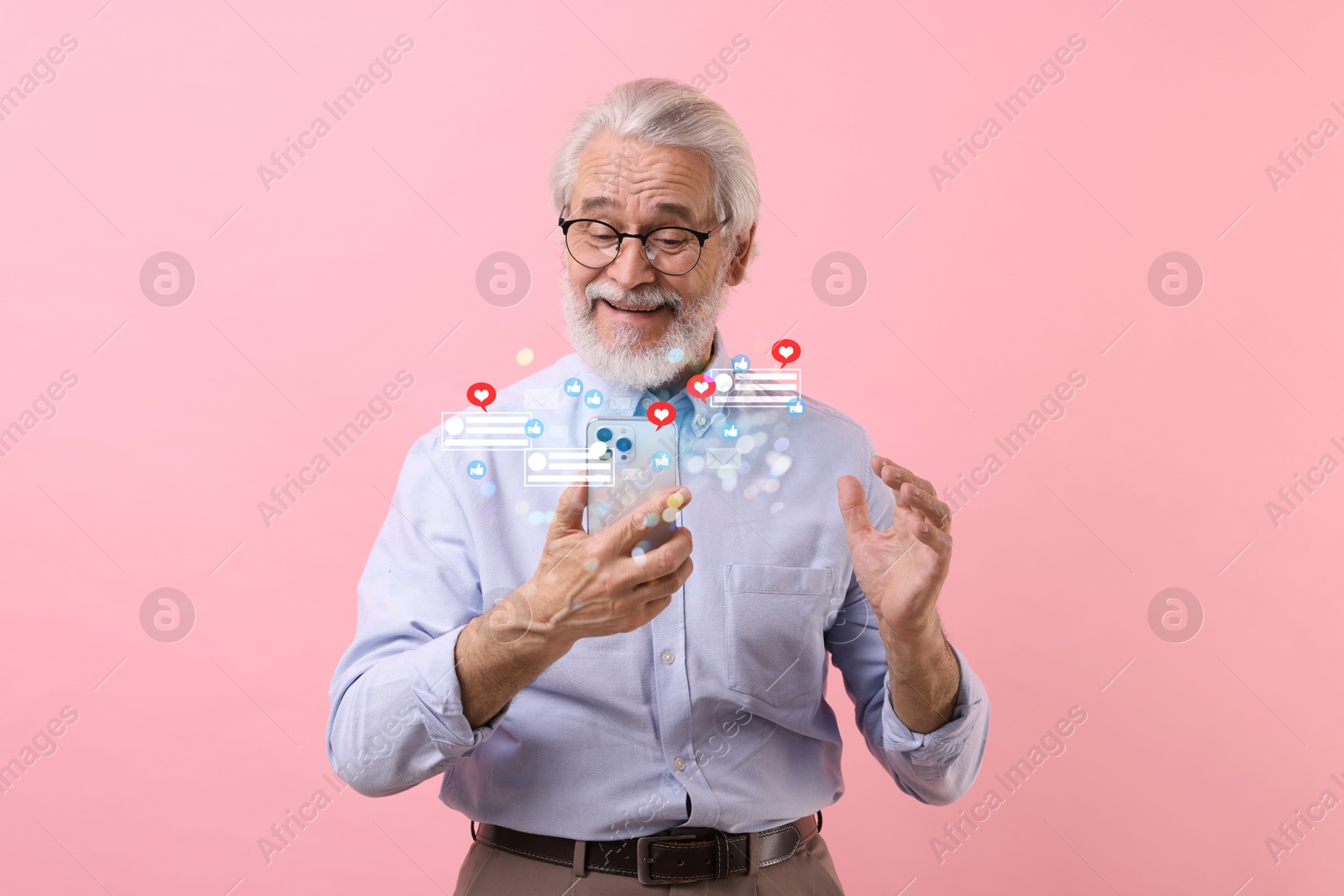 Image of Happy man using mobile phone on pink background. Different notification signs over gadget