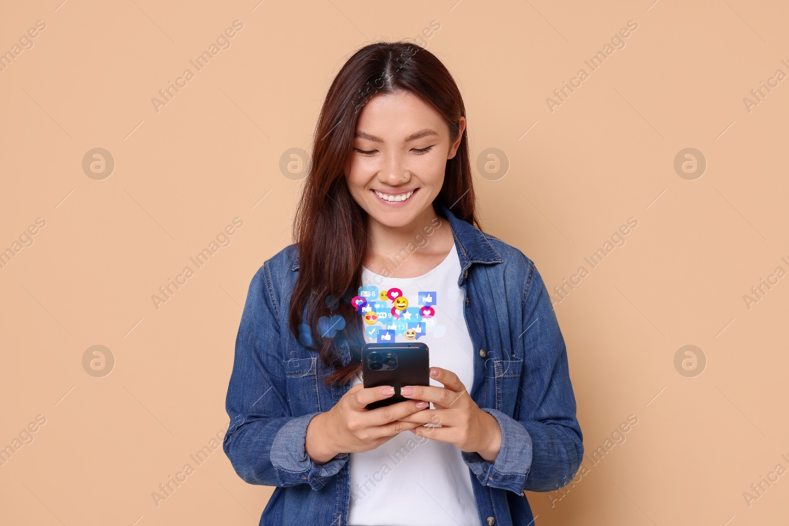 Image of Happy woman using mobile phone on dark beige background. New message sign and other notifications over gadget