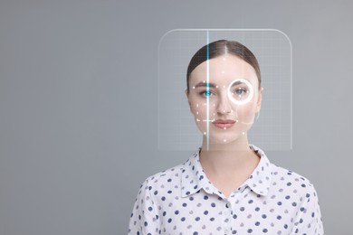 Facial and iris recognition system. Woman undergoing biometric verification on grey background