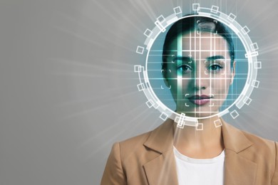 Facial recognition system. Woman undergoing biometric verification on grey background