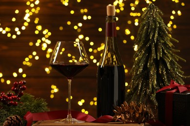 Red wine and Christmas decor against blurred lights