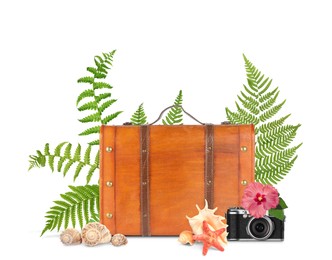 Brown travel suitcase, camera, seashells, sea star, tropical leaves and flower on white background