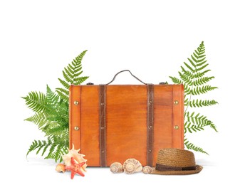 Brown travel suitcase, tropical leaves, hat, sea star and seashells on white background