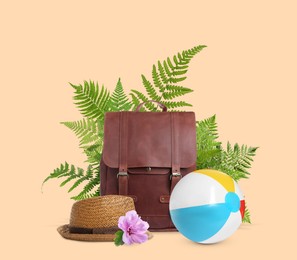 Image of Leather backpack, hat, beach ball, tropical leaves and flower on pink beige background. Time to travel