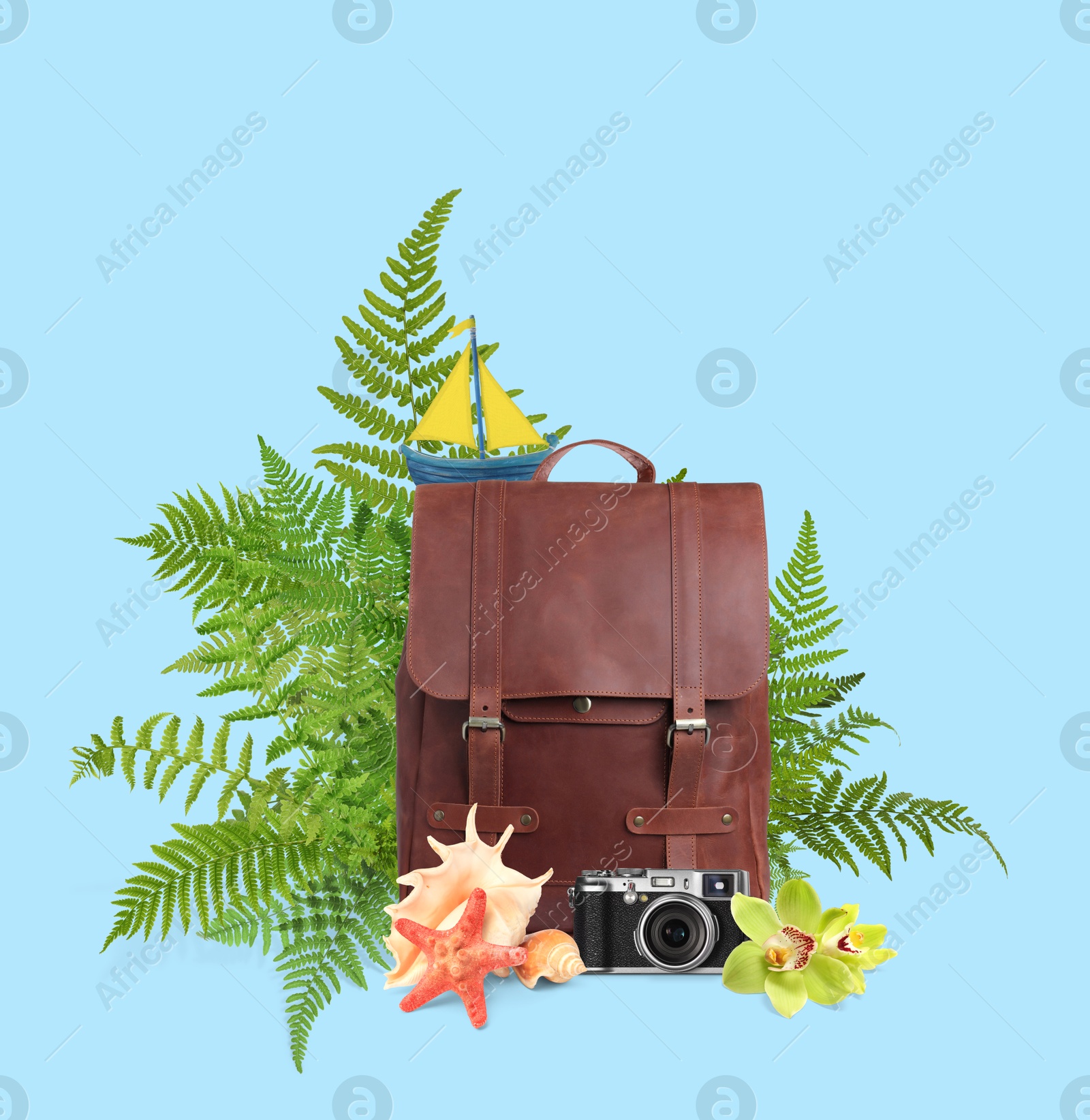 Image of Leather backpack, sea stars, seashells, camera, toy sailboat, tropical leaves and flowers on light blue background. Time to travel