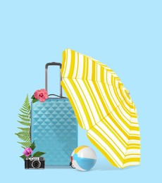 Image of Light blue travel suitcase, beach umbrella and ball, camera, tropical leaves and flowers on color background