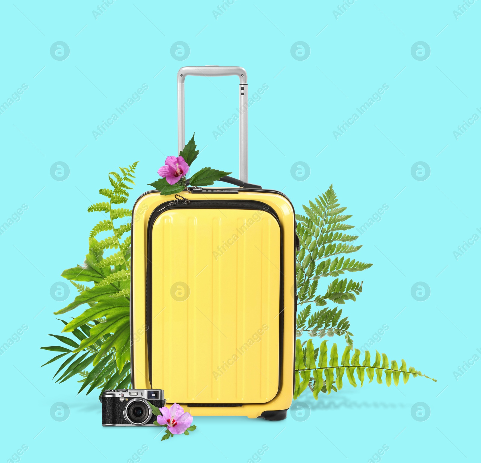 Image of Yellow travel suitcase, camera, tropical leaves and flowers on cyan color background