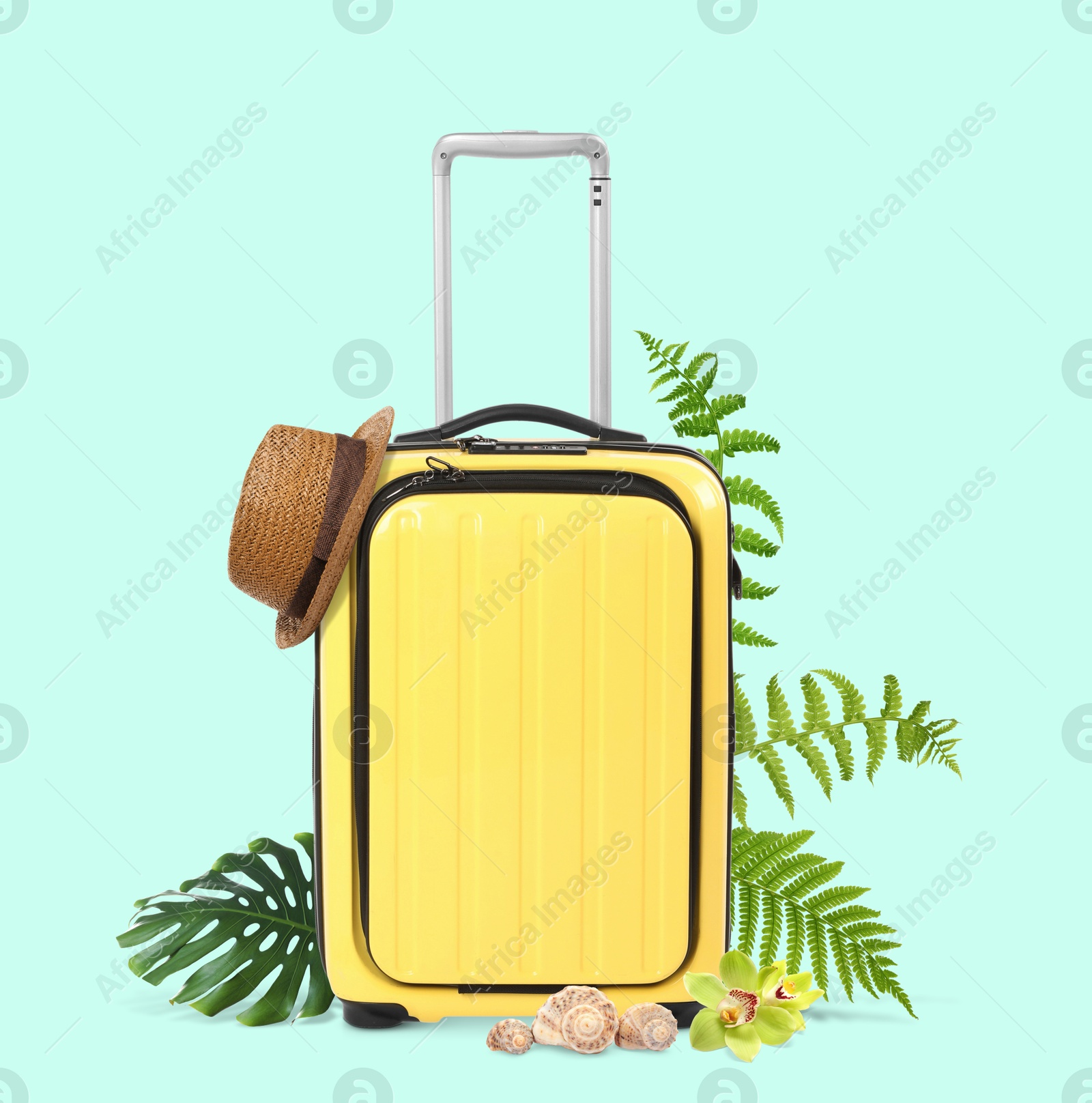 Image of Yellow travel suitcase, hat, seashells, tropical leaves and flowers on light blue background